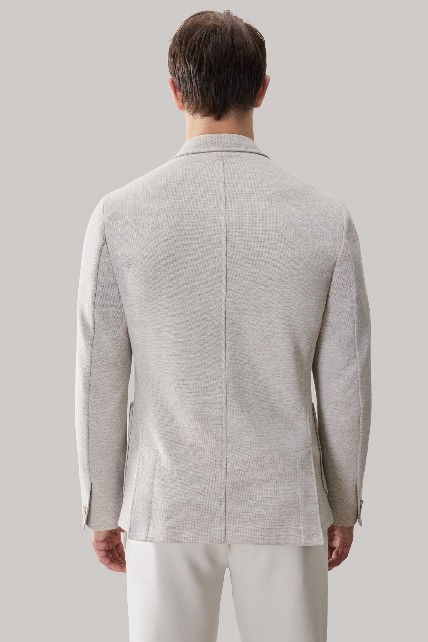 Light gray sportcoat with notch lapels, patch pockets, and button cuffs, shown from the back.