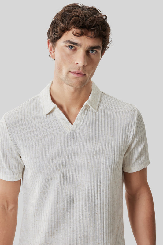 Beige ribbed short-sleeve polo shirt with open collar on male model against gray background.