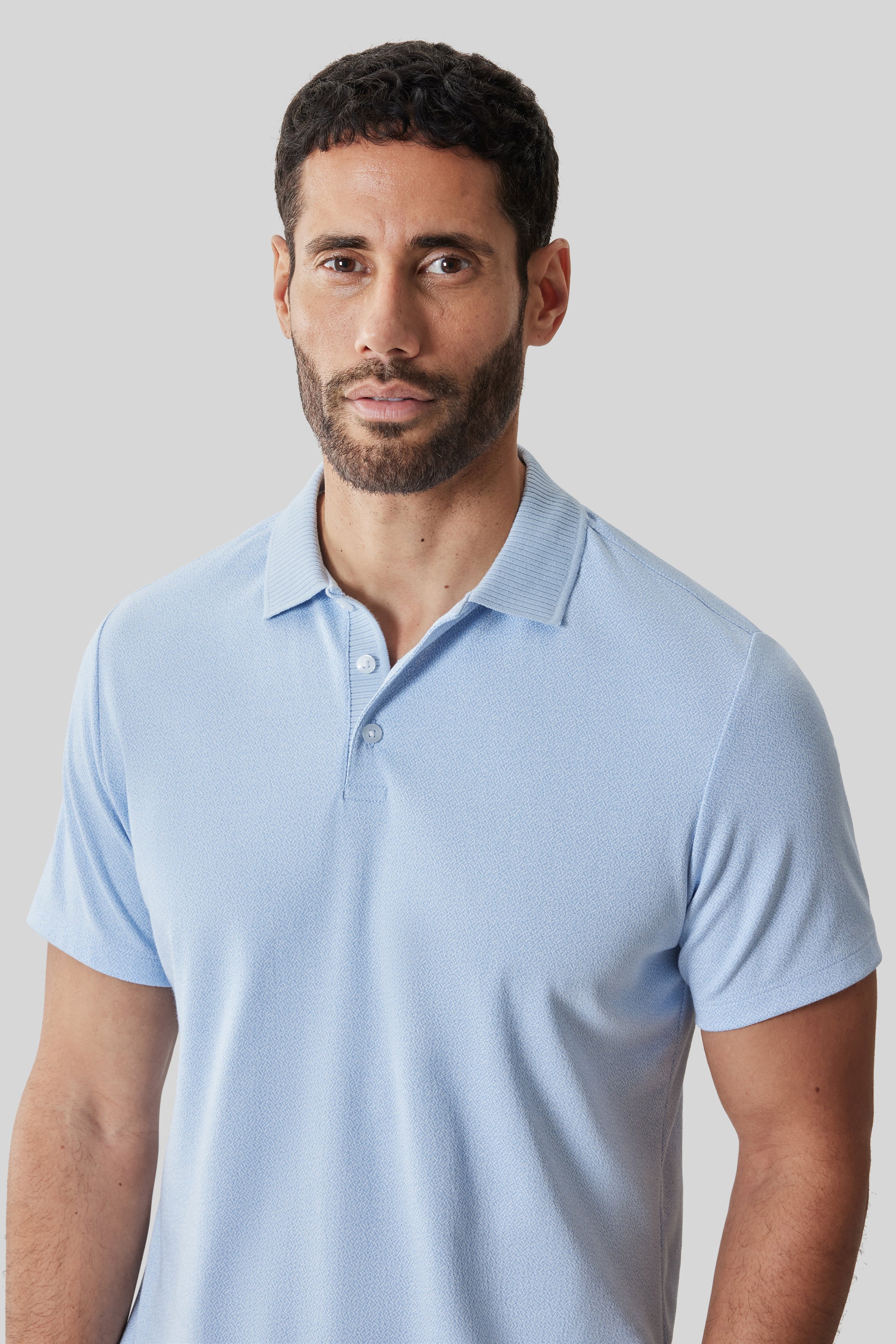 Light blue short sleeve polo shirt with button front placket on male model.