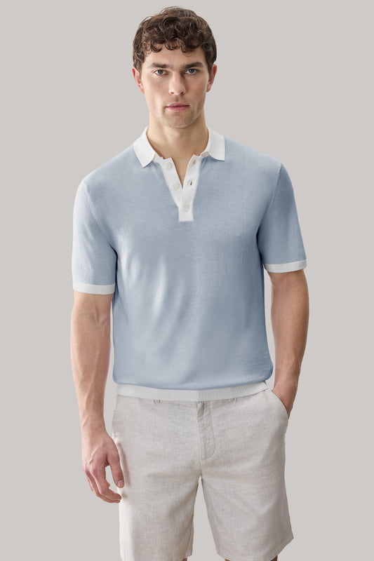 Light blue sweater polo with white collar and sleeve trim, worn with light tan pants.