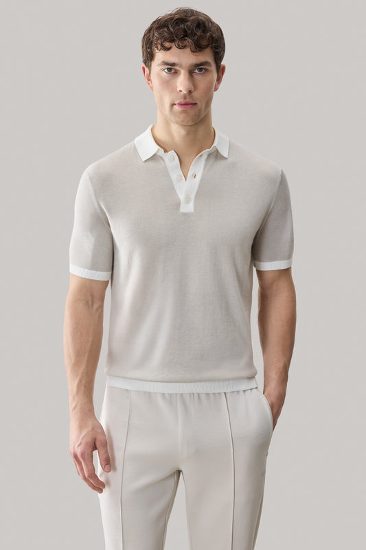 Beige sweater polo with white collar and trim, short sleeves with ribbed cuffs.