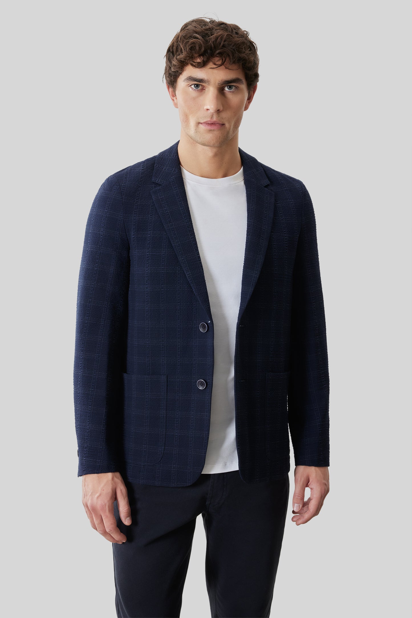 Navy check sportcoat with notch lapels and two-button closure worn over white t-shirt.