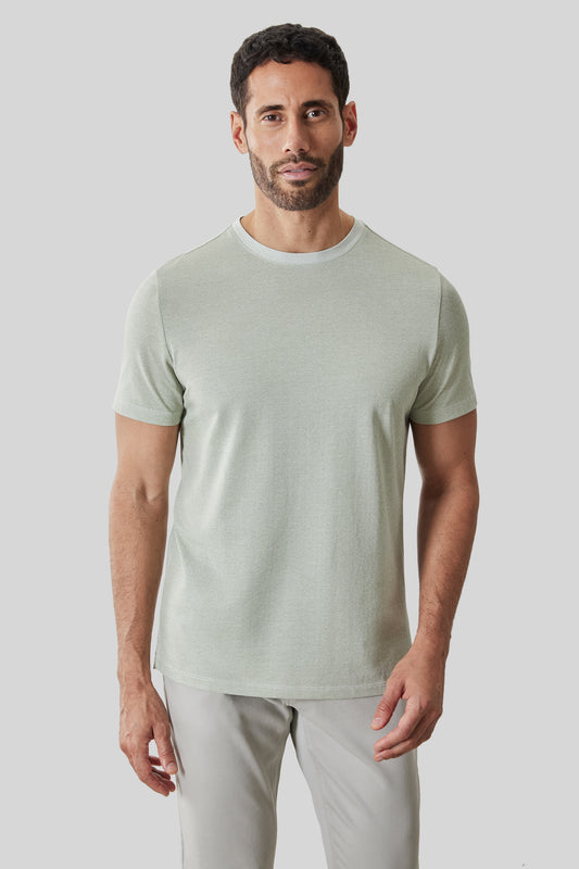 Man wearing a light green short-sleeve crewneck t-shirt with a relaxed fit.