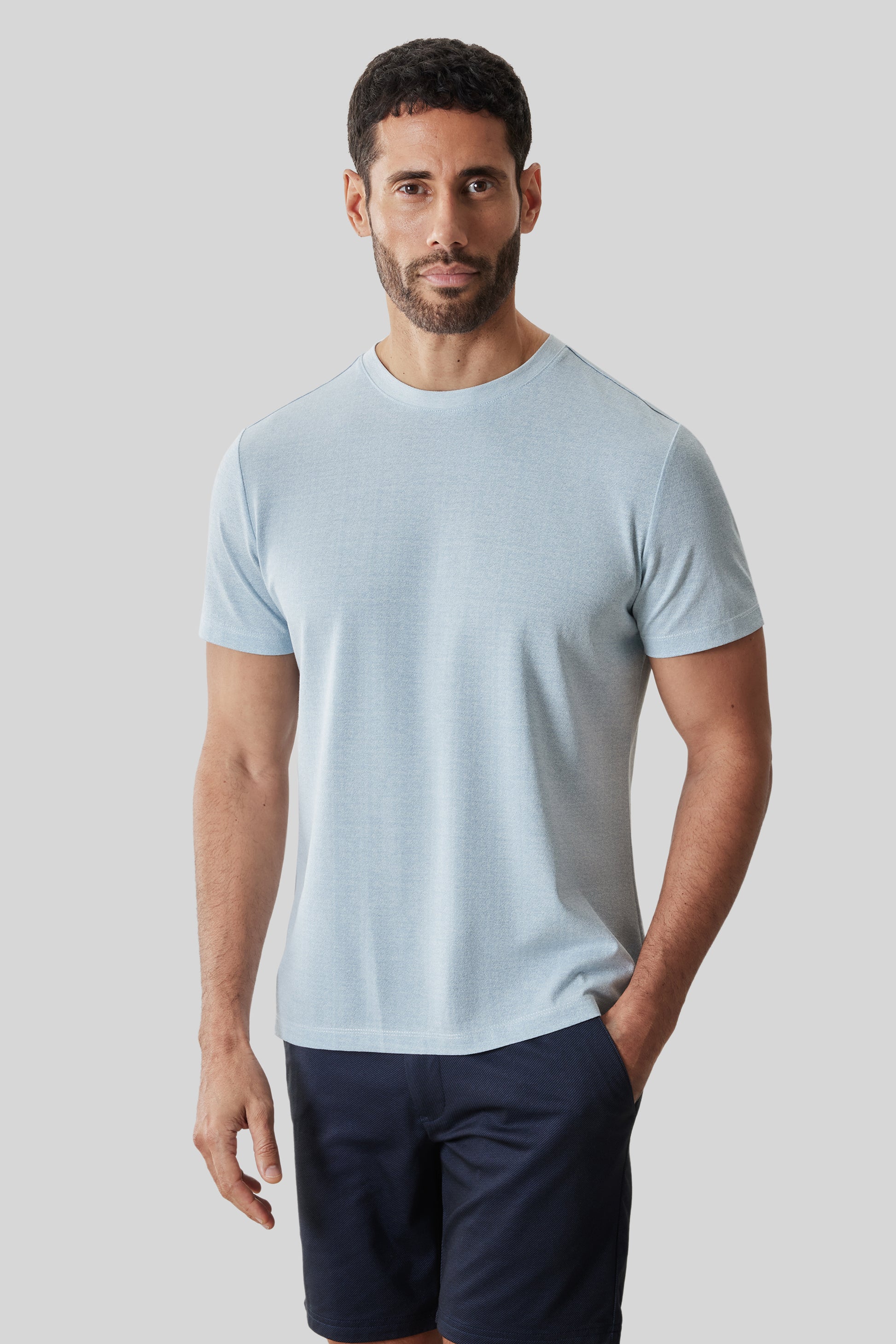 Man wearing light blue short-sleeve crew neck t-shirt with navy shorts.