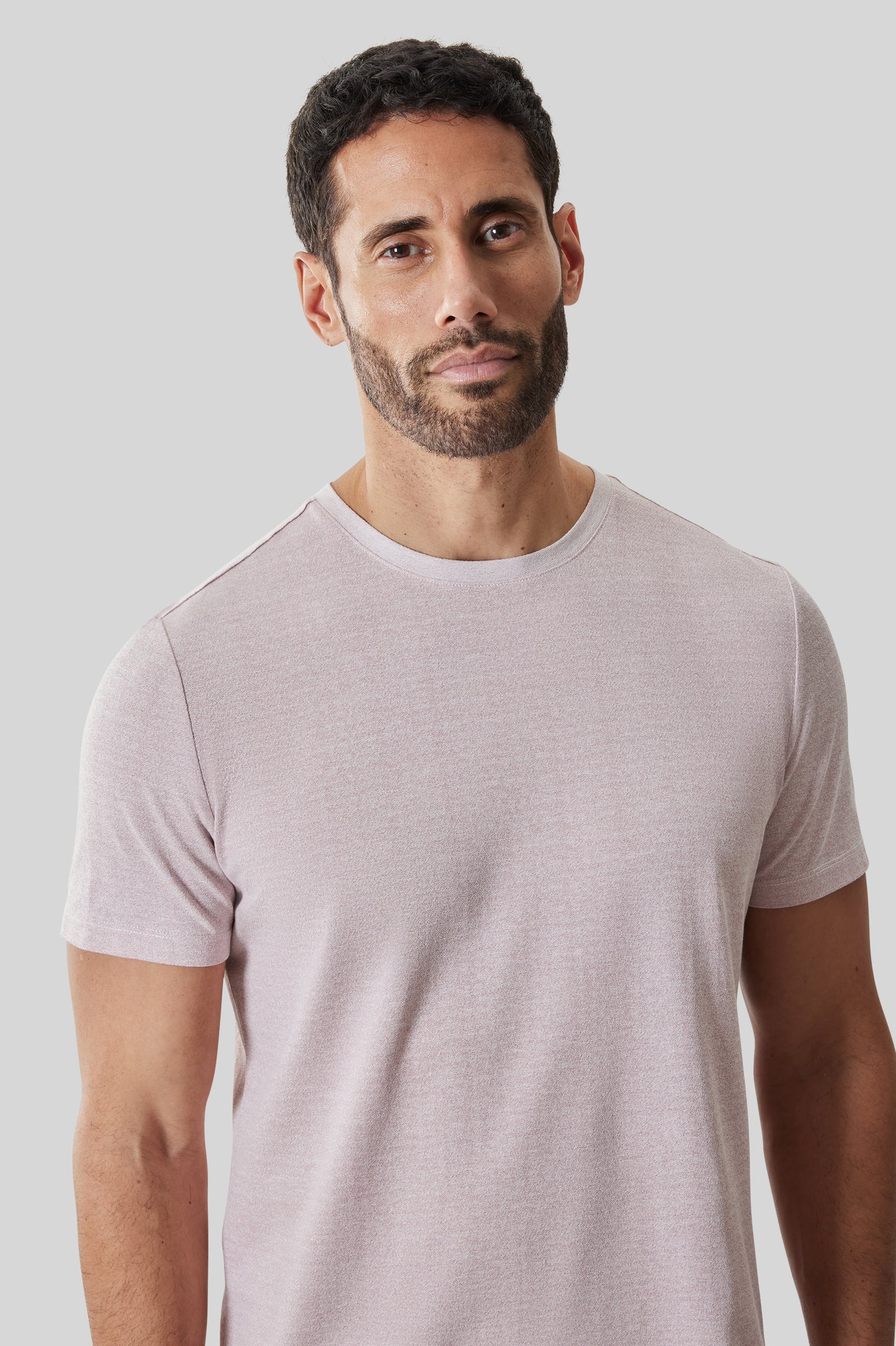 Man wearing a light mauve short-sleeve crewneck tee with a relaxed fit.
