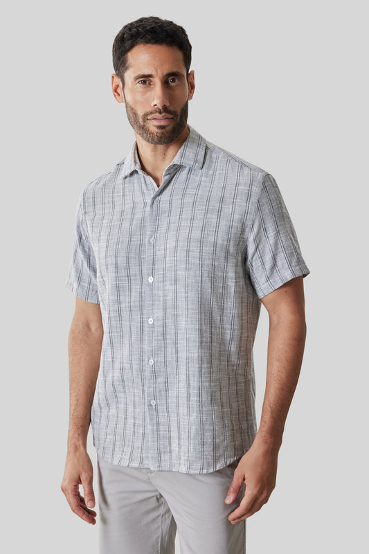 Man wearing a light gray short-sleeve button-up shirt with vertical stripe pattern.