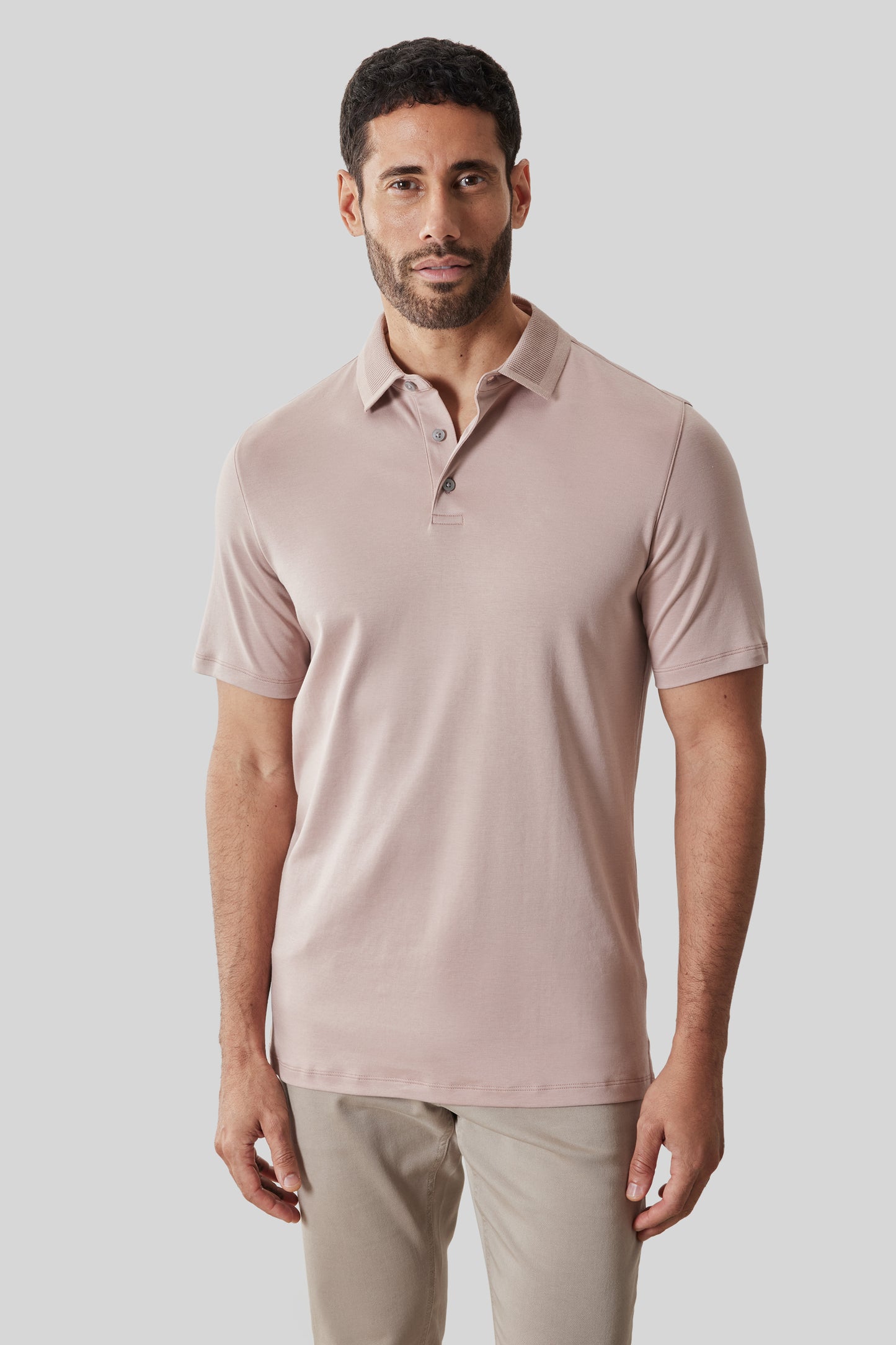 Mauve textured short-sleeve polo with button-front collar worn by man in neutral pants.