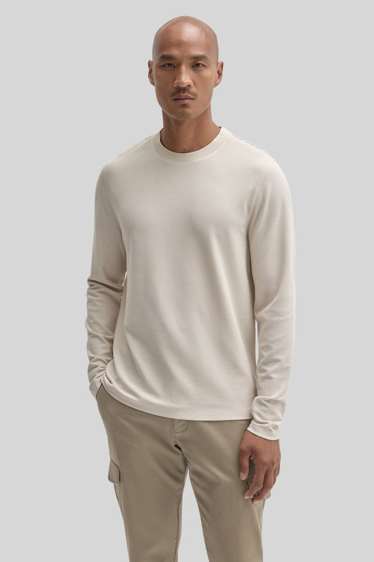 Cream long sleeve crew neck shirt on a model wearing tan cargo pants.