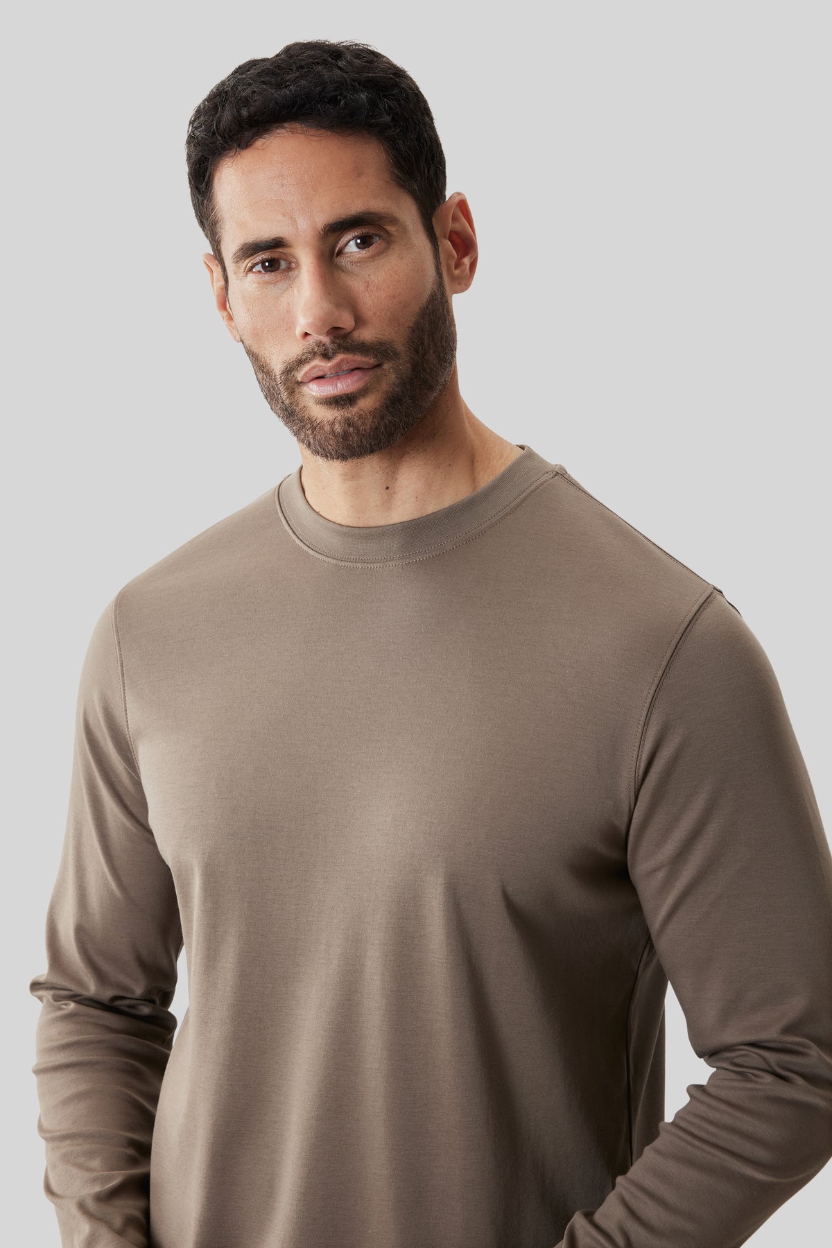 Man wearing taupe long-sleeve crew neck sweatshirt.
