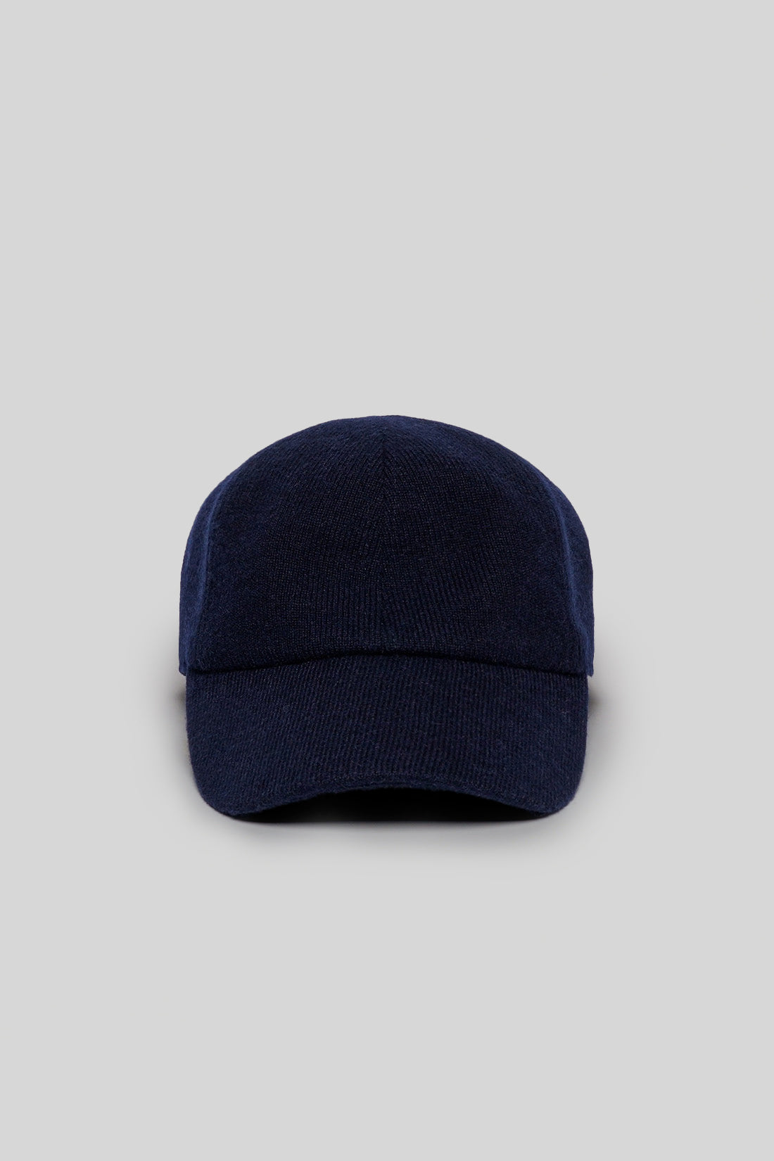 Navy knit baseball cap with a textured ribbed crown and curved brim.