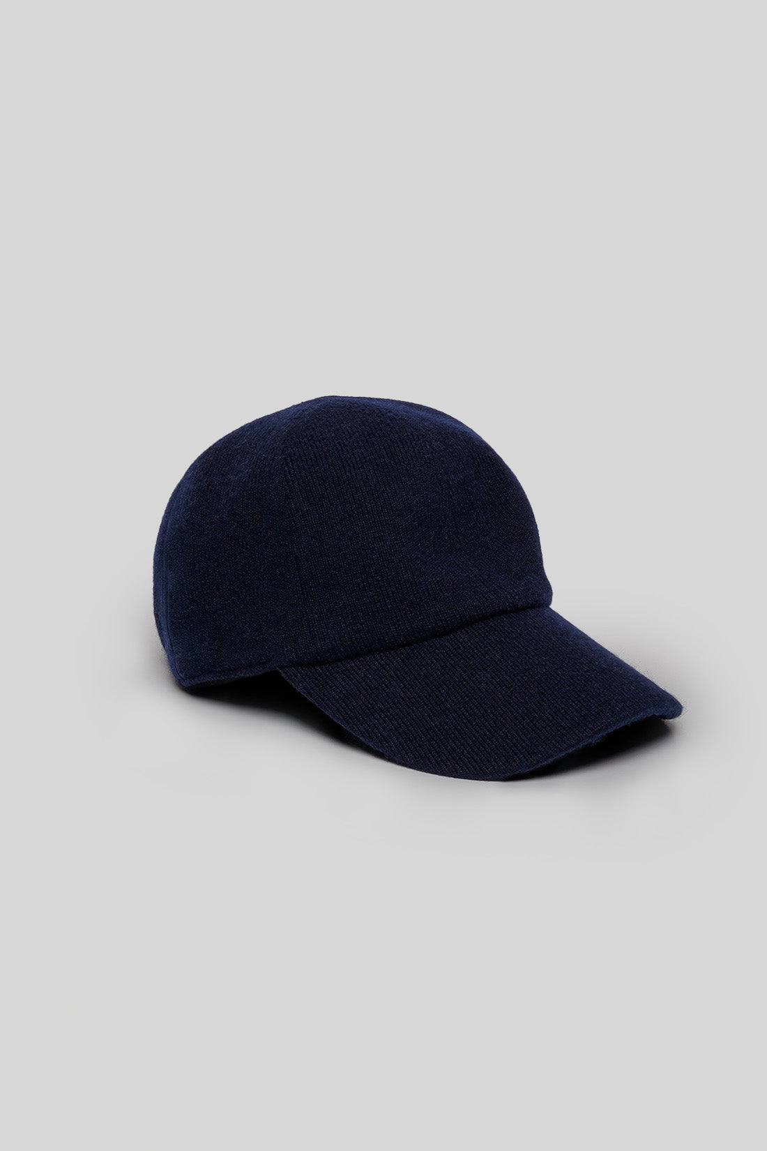 Navy knit baseball cap with ribbed texture and curved bill.