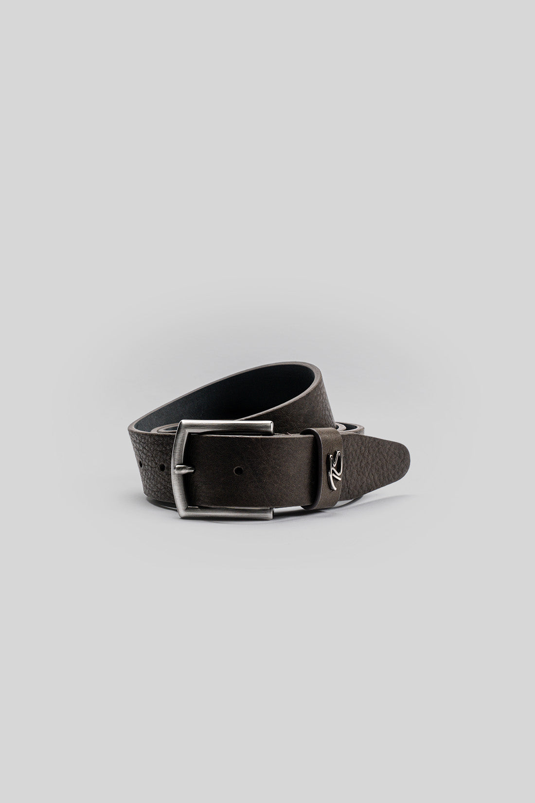 Black leather belt with silver rectangular buckle and textured finish, coiled on white background.