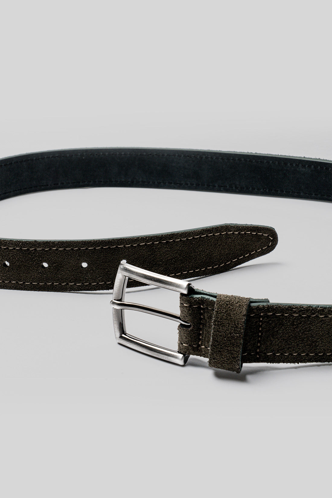 Black leather belt with white stitching, metal buckle, and punched holes along the strap.
