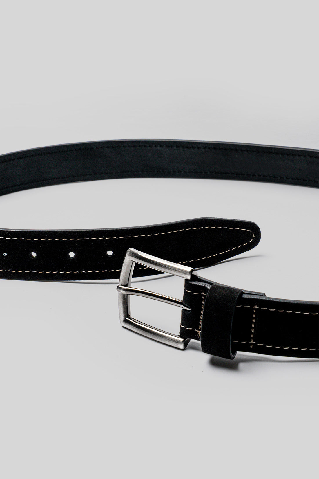 Black leather belt with white stitching, metal buckle, and perforated holes along the length.