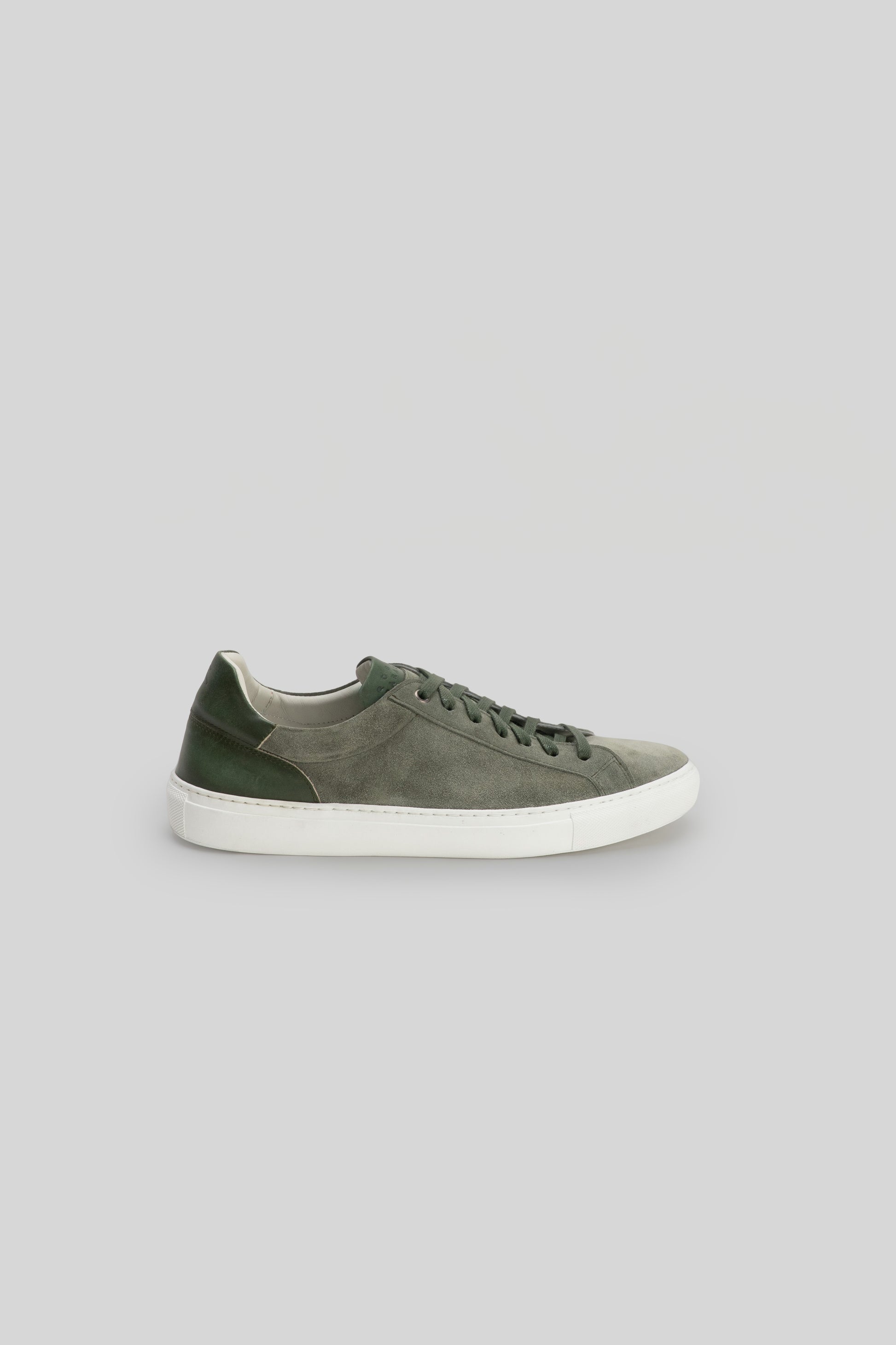 Gray and green suede sneaker with white rubber sole and dark laces, shown in profile view.