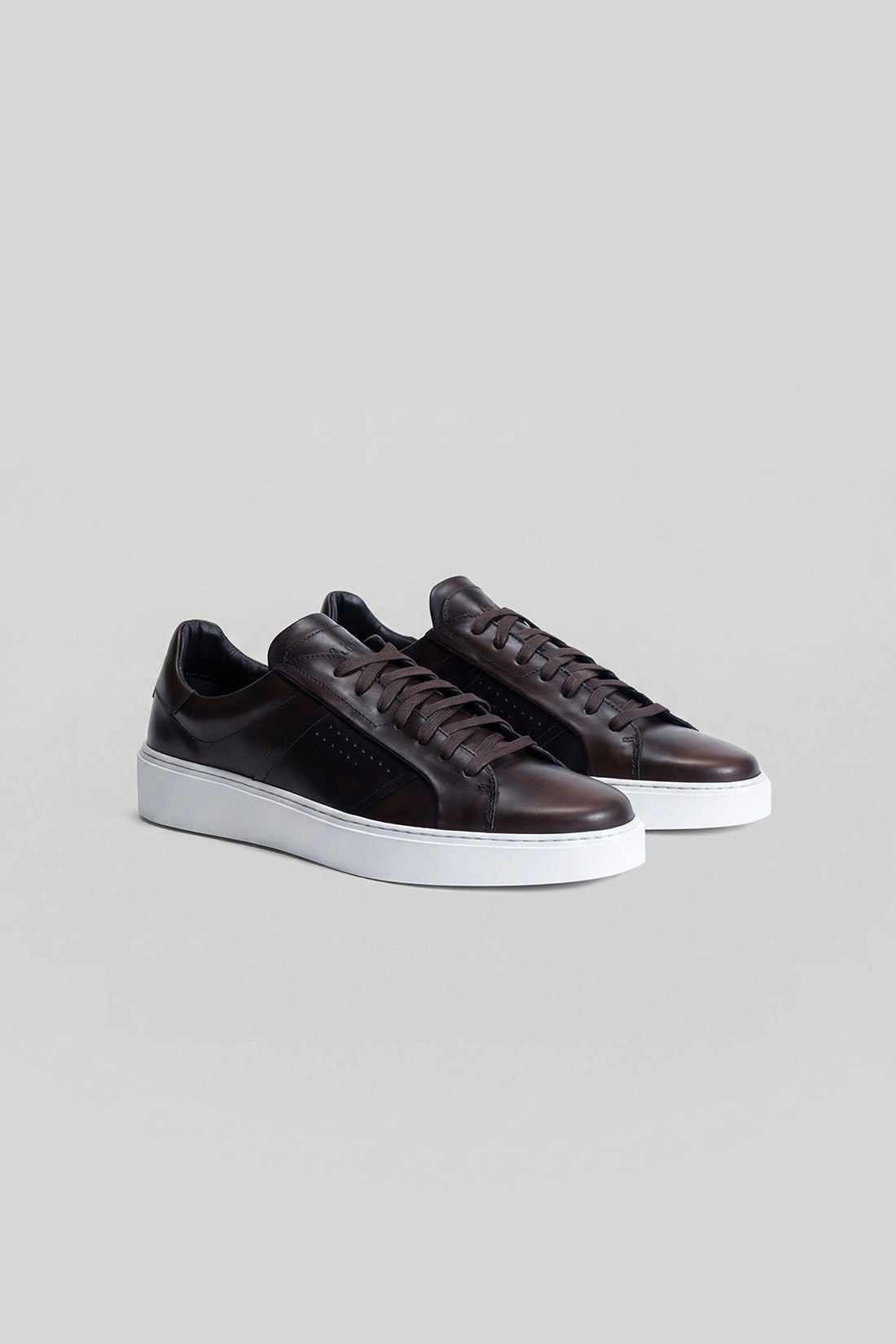 Black leather sneakers with white platform sole and lace-up closure, shown as a pair.