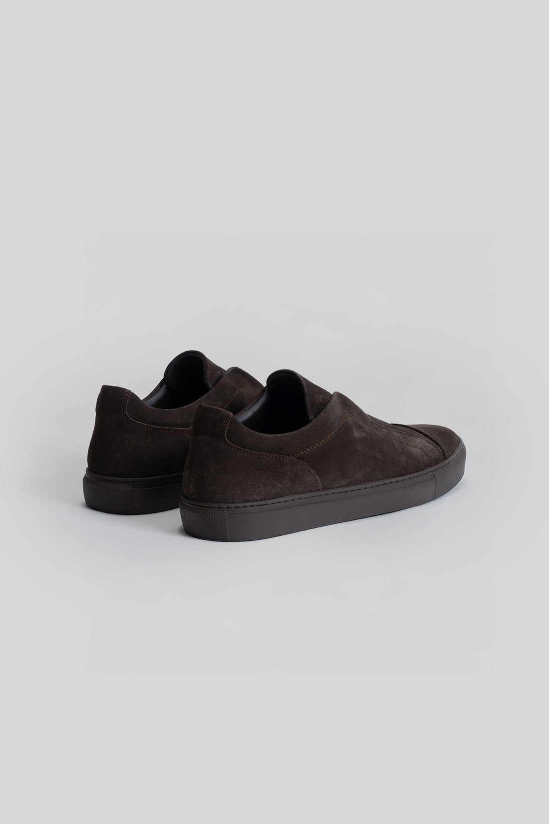 Dark gray suede slip-on sneakers with black platform soles, shown from the back angle.