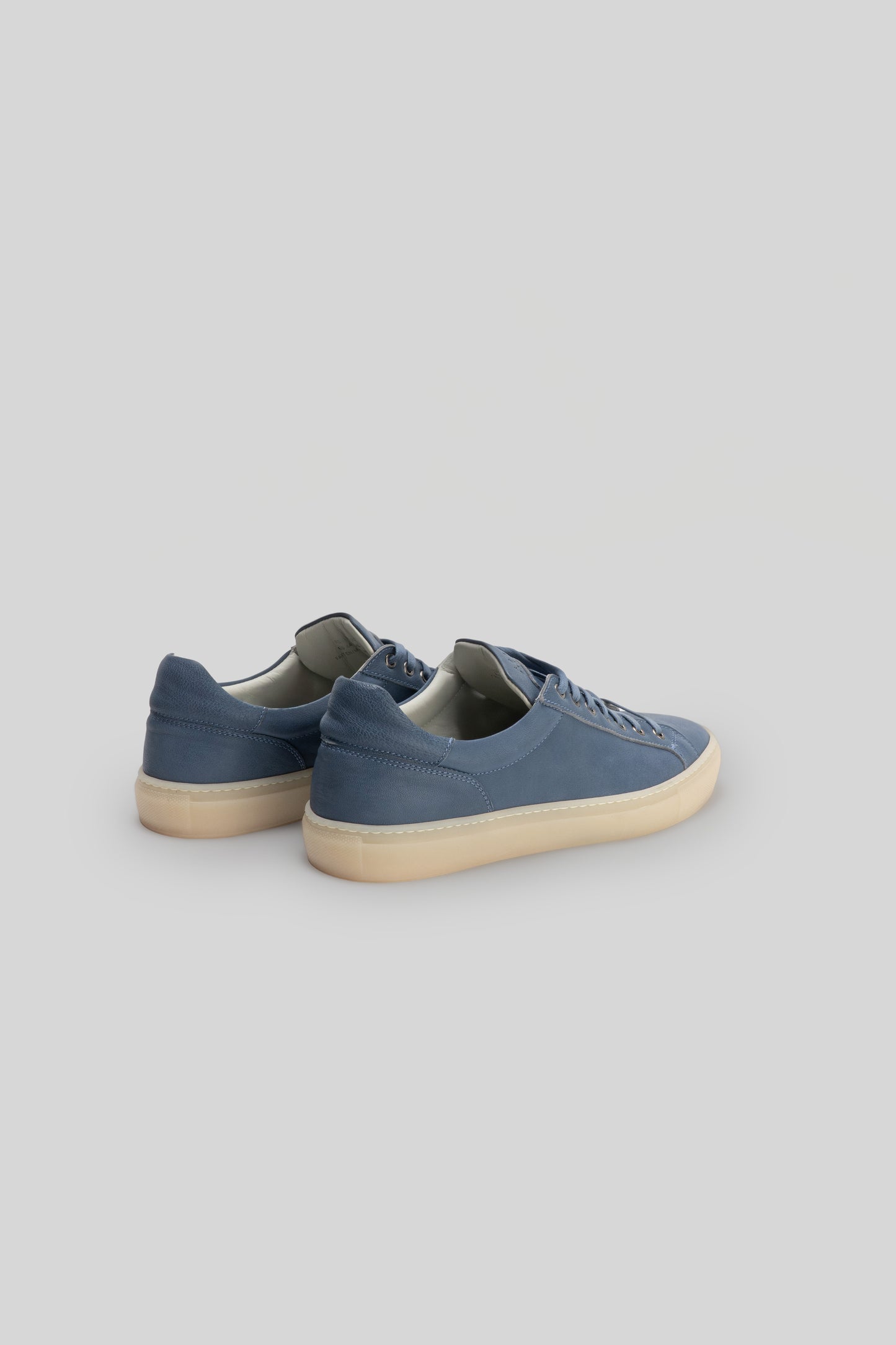 Blue leather sneaker with cream-colored sole, shown from back three-quarter view.