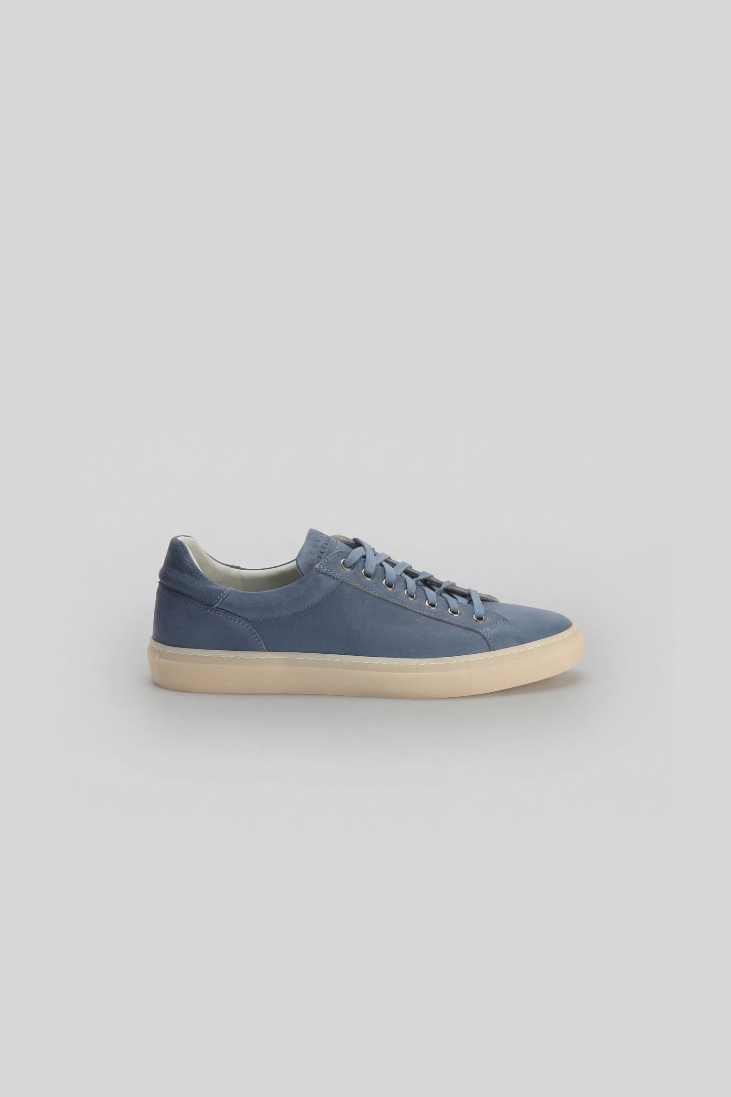 Blue leather sneaker with cream sole and lace-up front closure, shown from the side profile.
