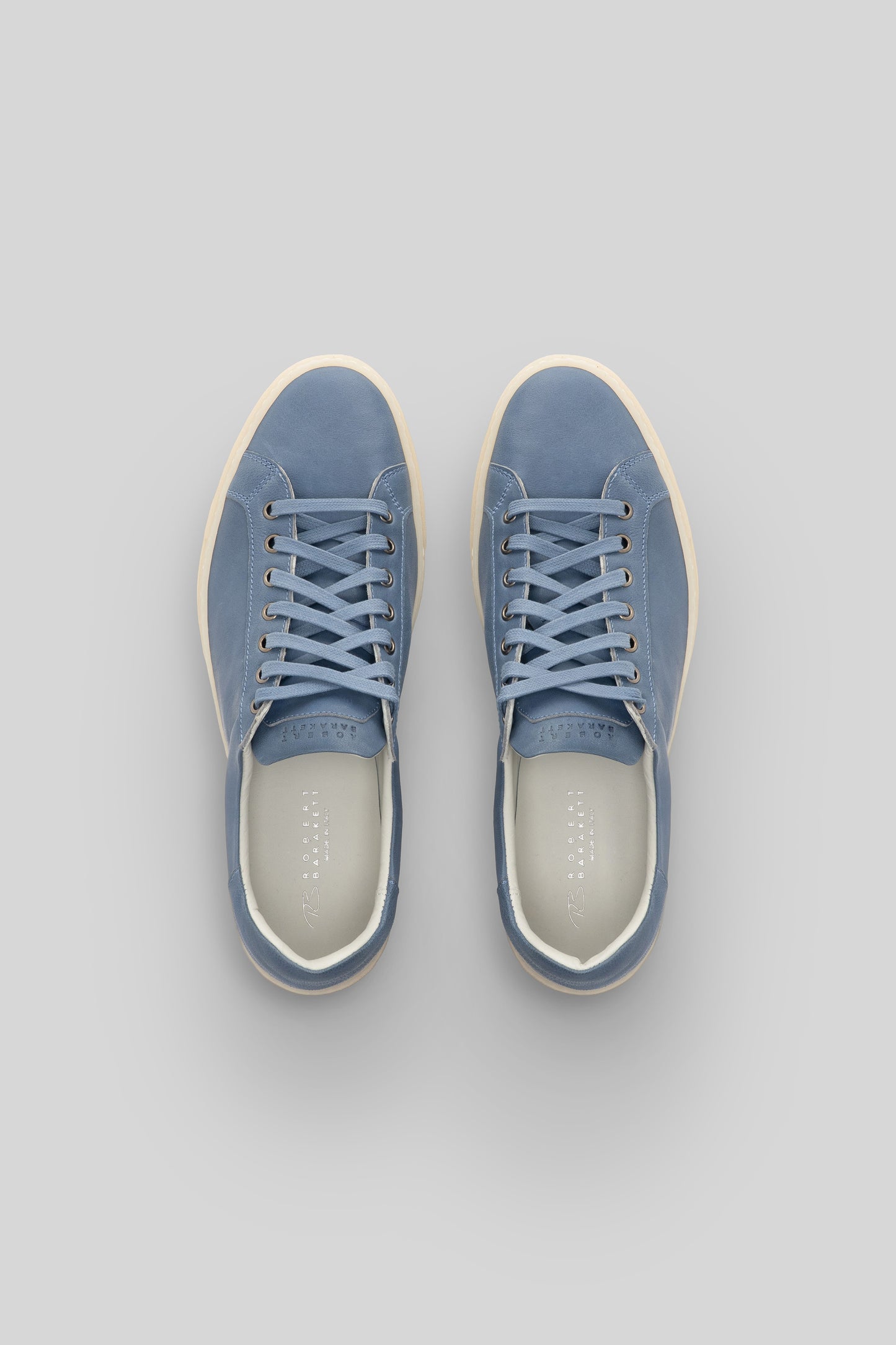 Blue leather sneakers with cream laces and cream rubber sole, shown from above.