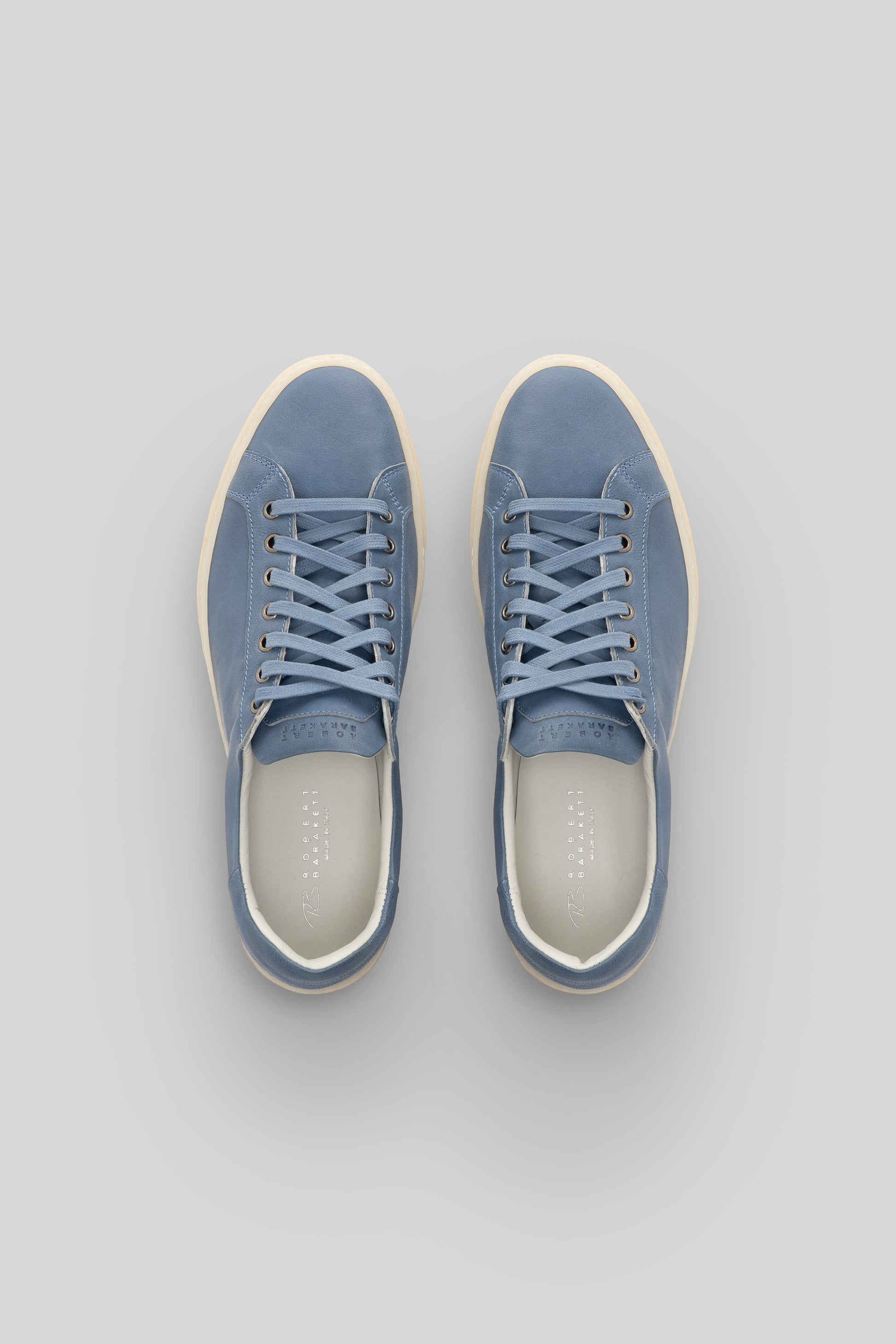 Blue leather sneakers with cream laces and cream rubber sole, shown from above.