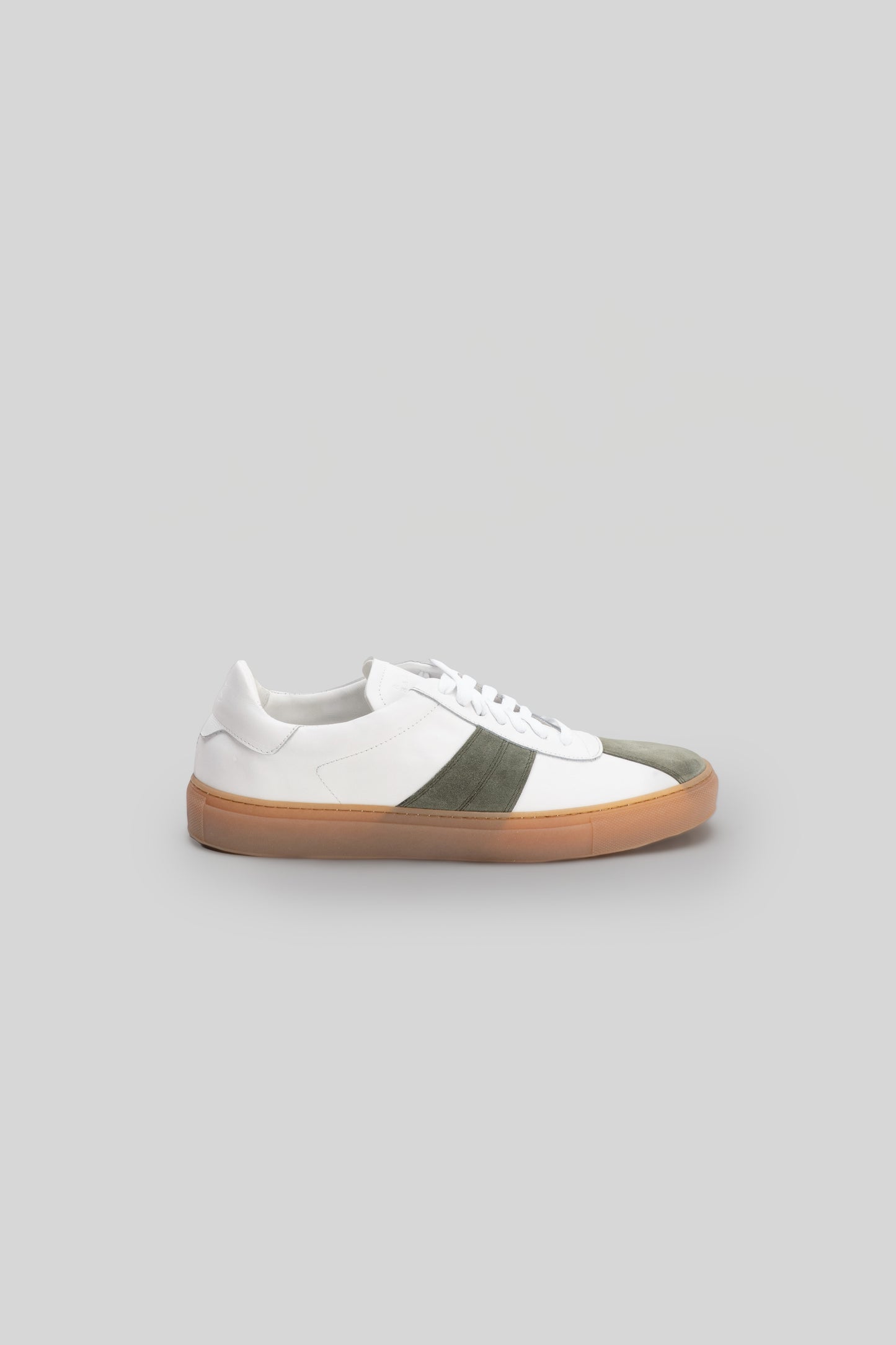 White leather sneaker with olive green stripe across side and tan rubber sole.