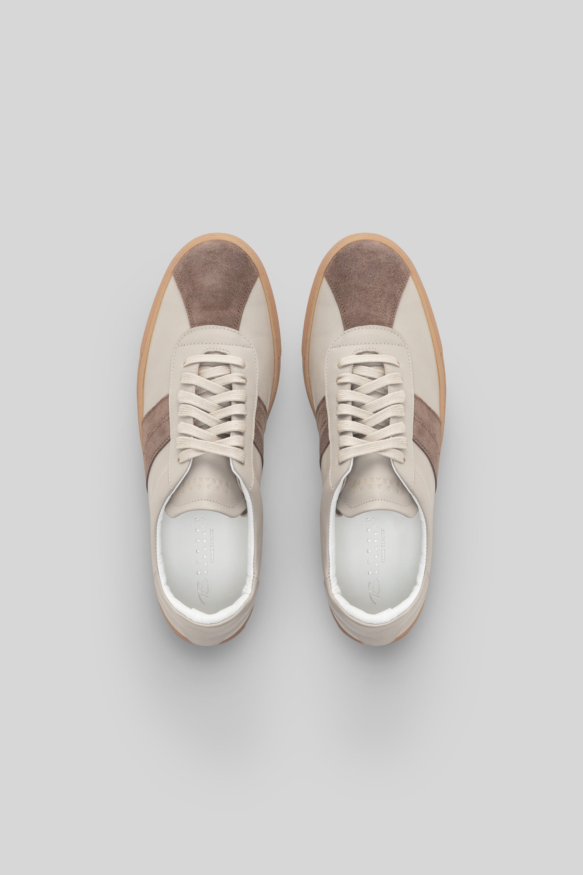 Pair of cream and taupe striped sneakers with lace-up closure and gum sole, viewed from above.