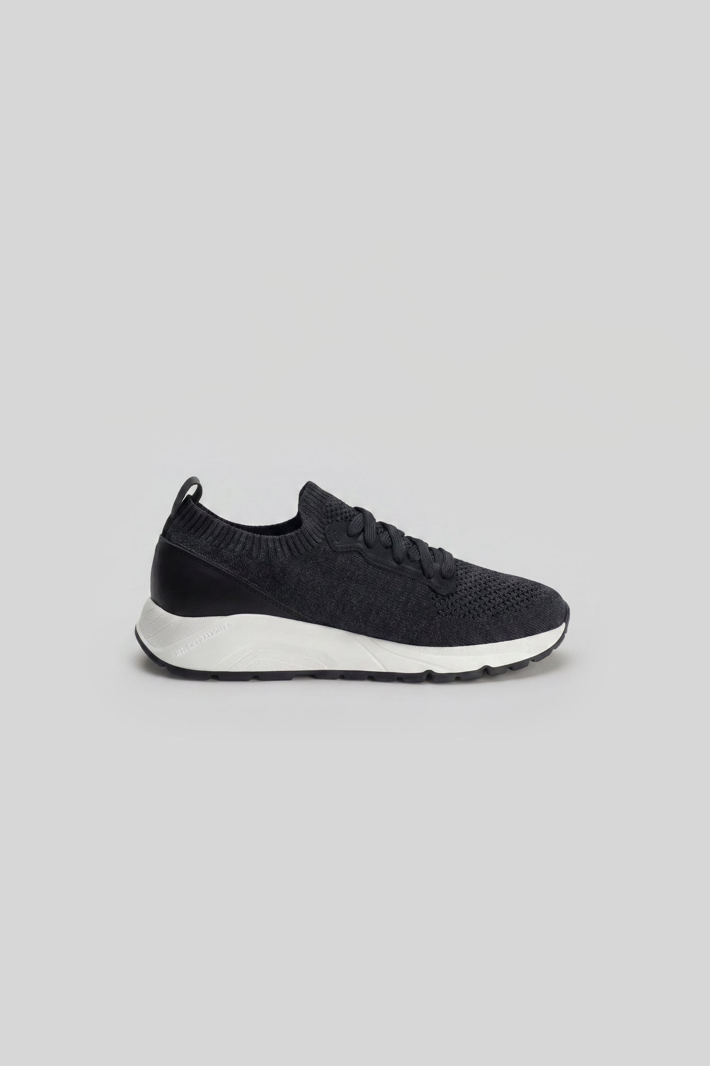 Black knit sneaker with white sole and lace-up closure, shown in side profile.