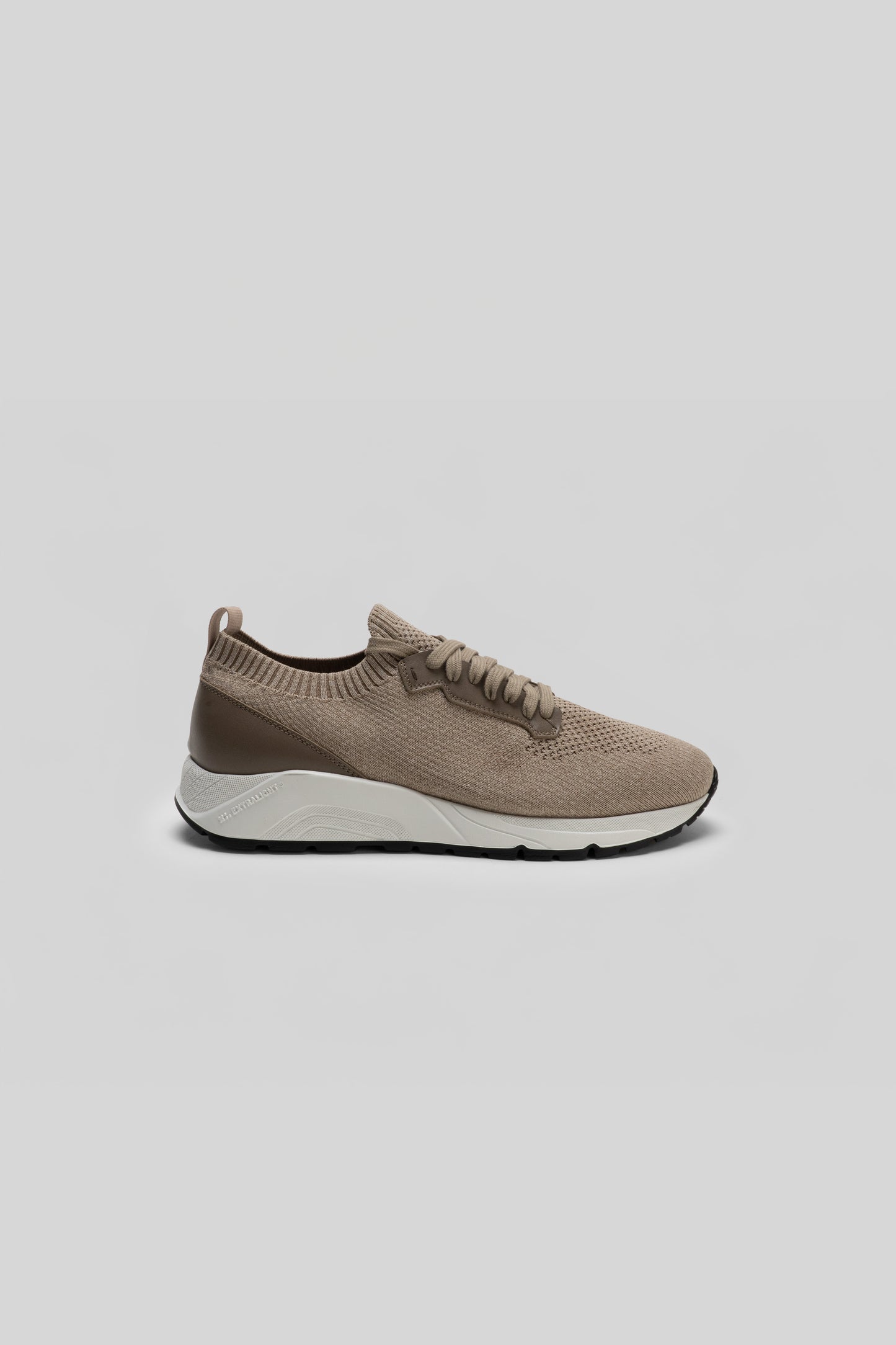 Bryce knit sneaker with taupe textured upper, white midsole, and black sole, shown in profile view.