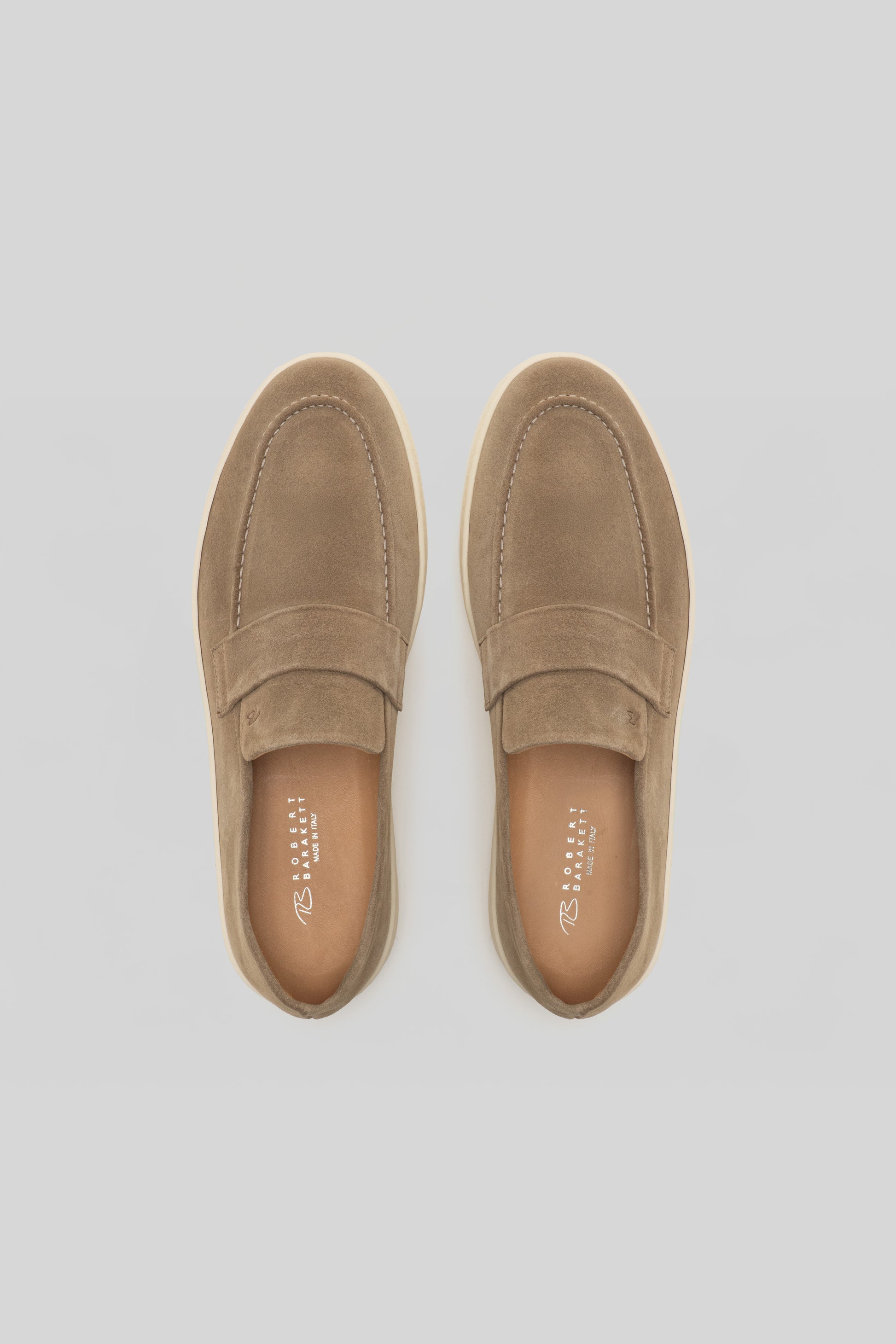 Pair of tan suede loafers with stitched detailing and cushioned insoles, shown from above.