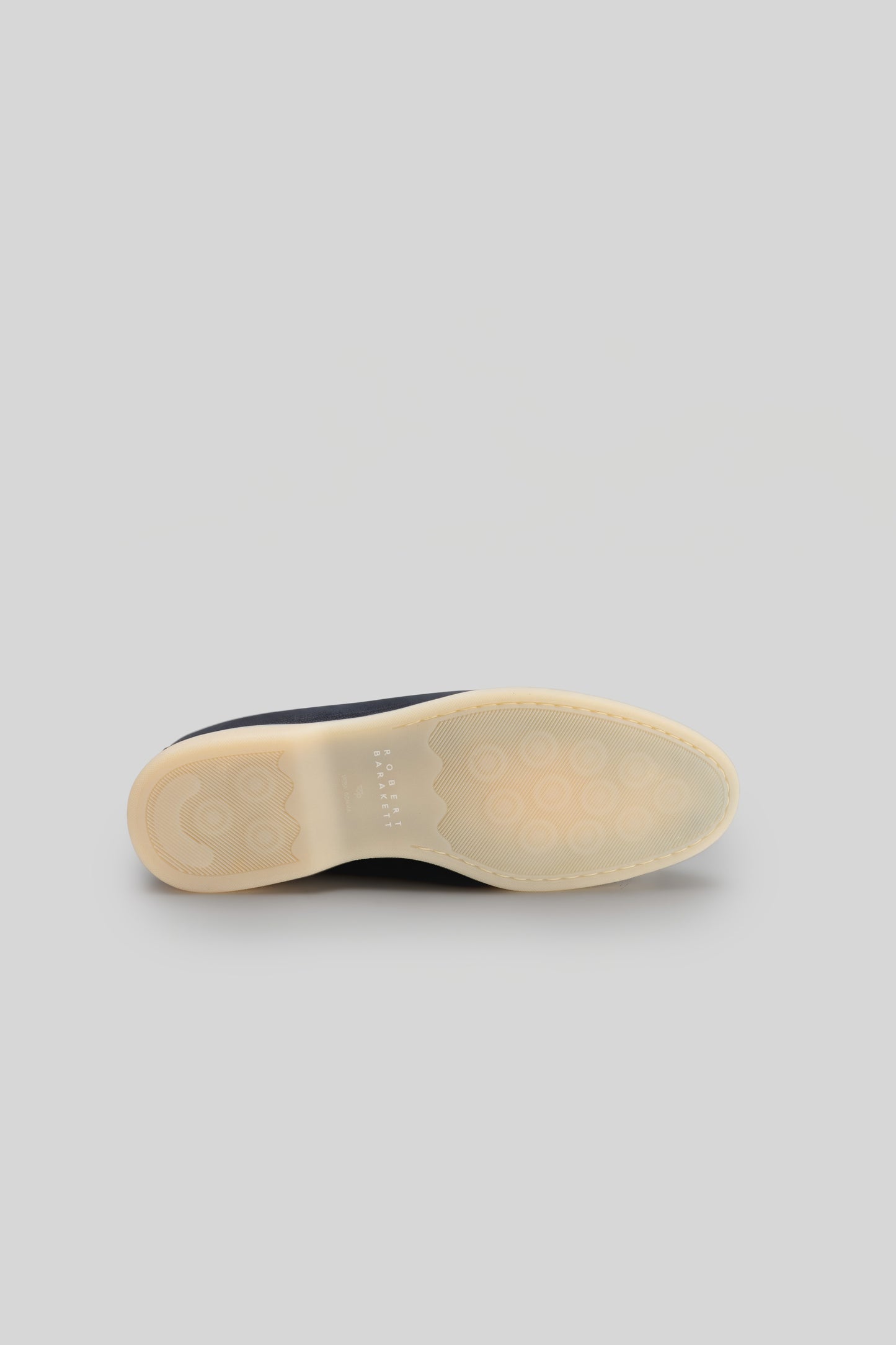 Navy and cream loafer sole with textured ribbed pattern and curved heel support.