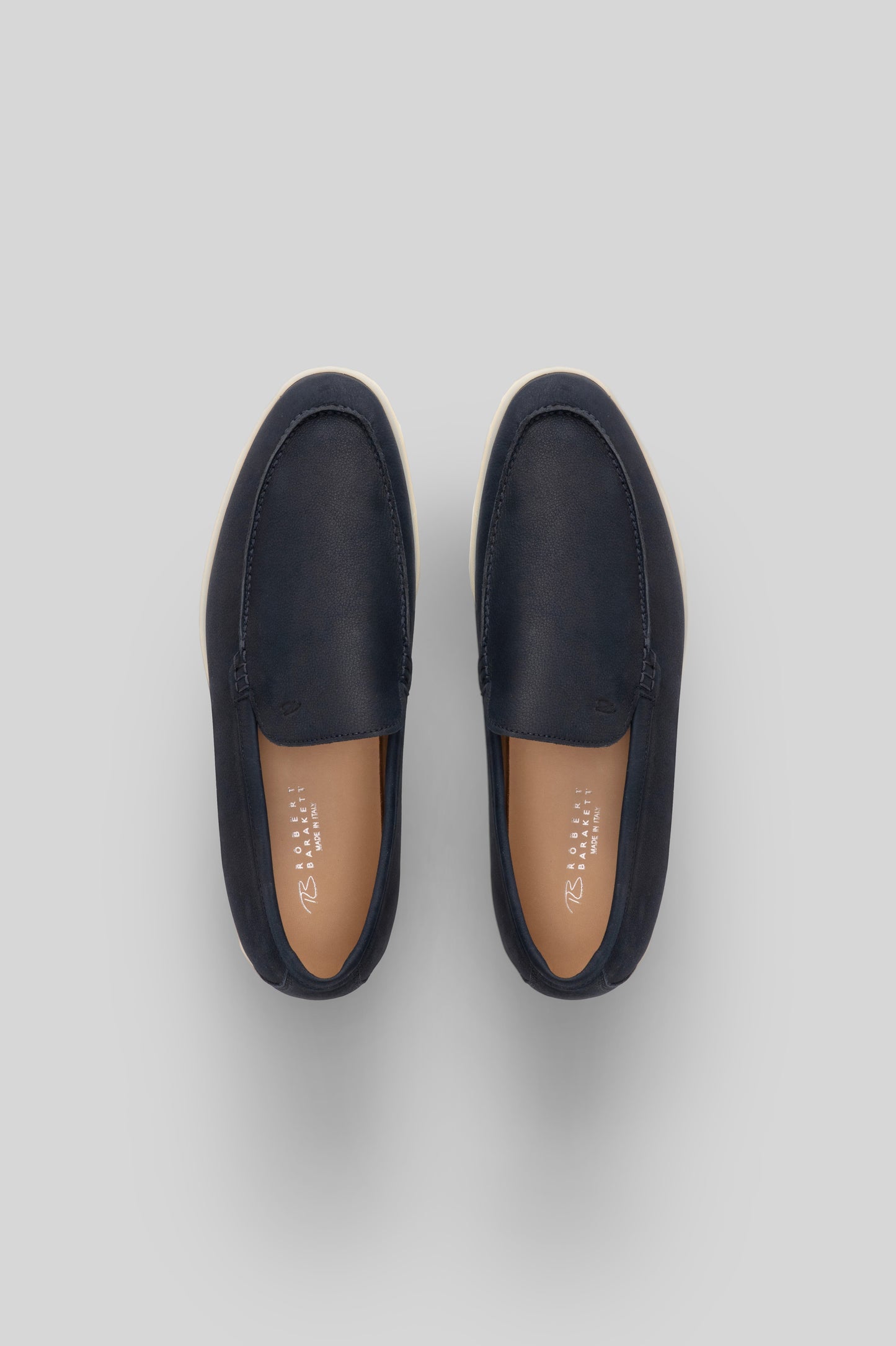 Navy leather loafers with tan leather insoles, shown from above.