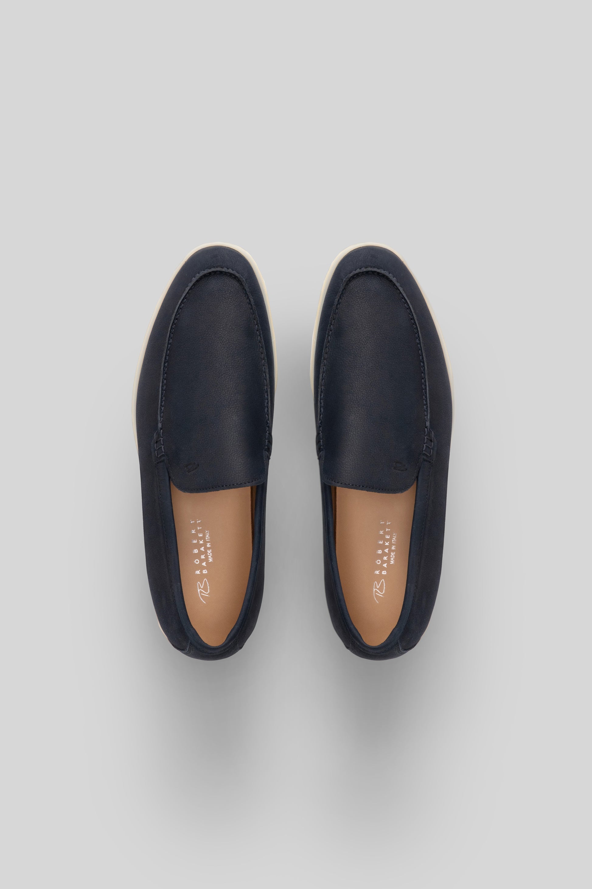 Navy leather loafers with tan leather insoles, shown from above.