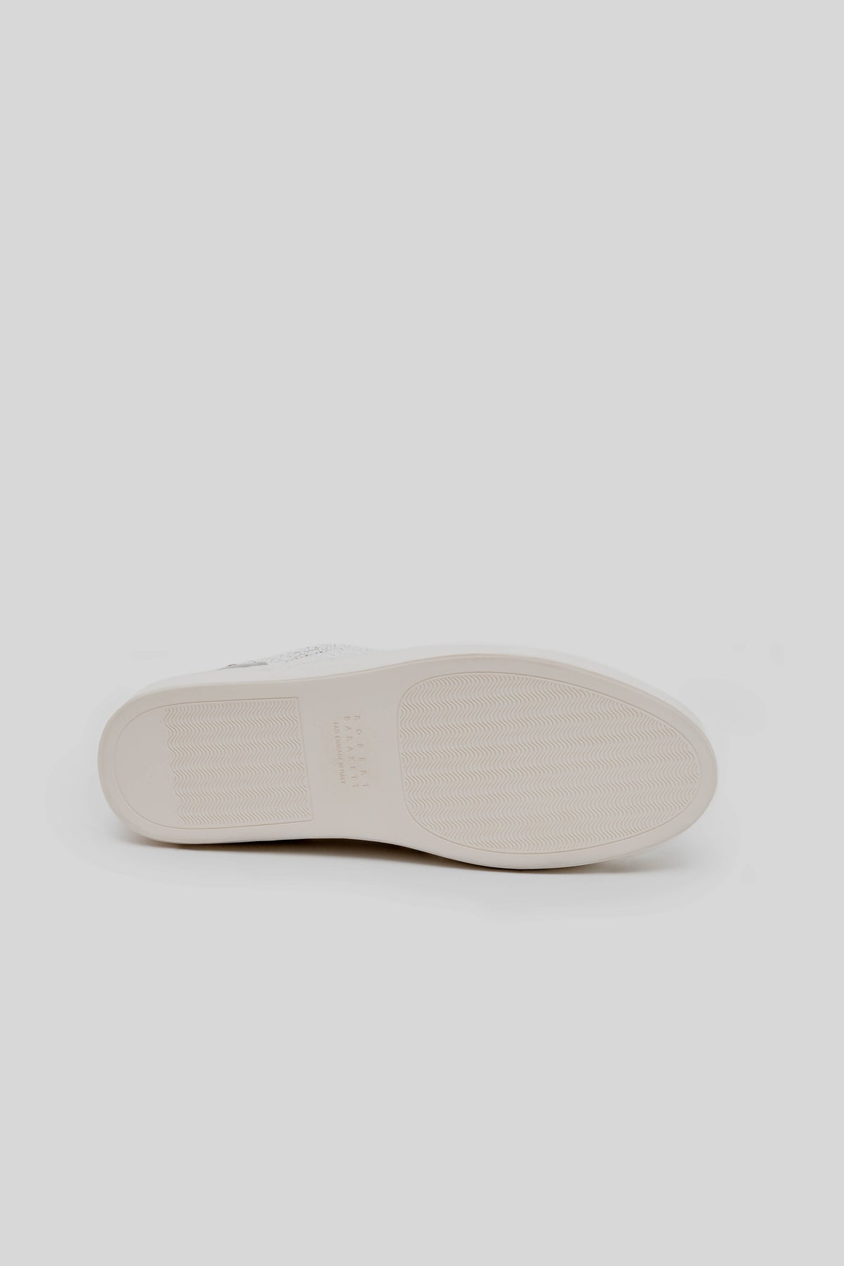 White sneaker sole with herringbone tread pattern, displayed from the bottom view.